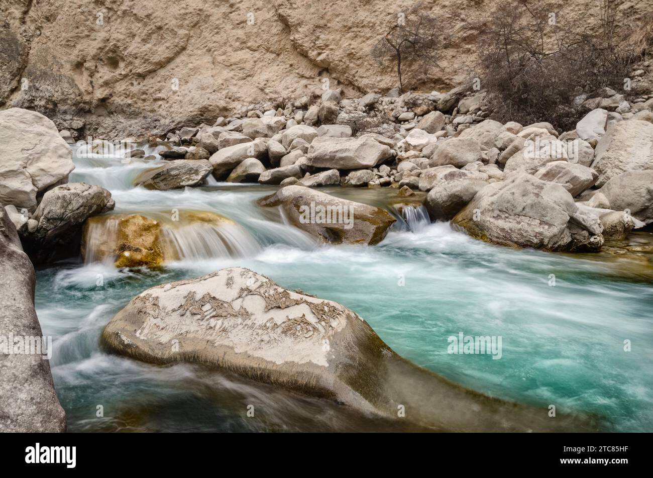 Une rivière d'eau douce parmi les rochers. Aqua frais écoulement rapide dans les pierres. Une rivière forestière avec de l'eau froide propre. Printemps frais dans les montagnes. Banque D'Images