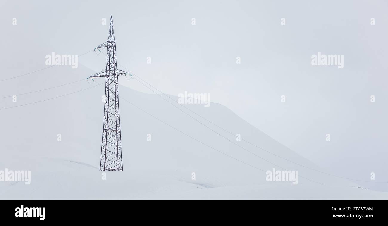 Une photo d'une tour de transmission dans une montagne complètement blanche couverte de neige Banque D'Images
