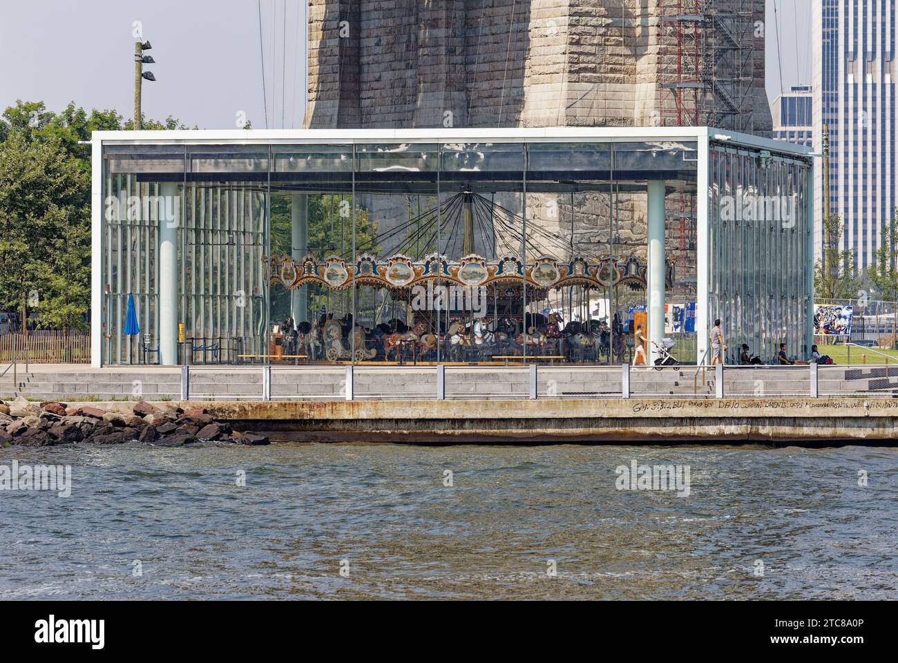 Jane’s Carousel se dresse à l’ombre du pont de Brooklyn. L’amusement pour enfants entouré de verre a été déplacé de Youngstown, Ohio. Banque D'Images