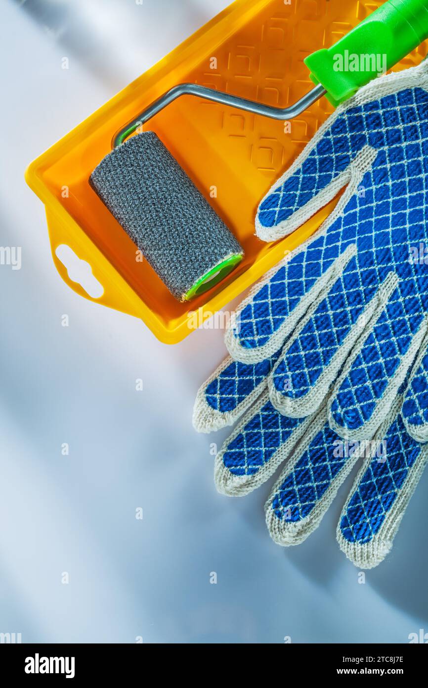 Paire de gants de sécurité rouleau de bac à peinture sur fond blanc Banque D'Images
