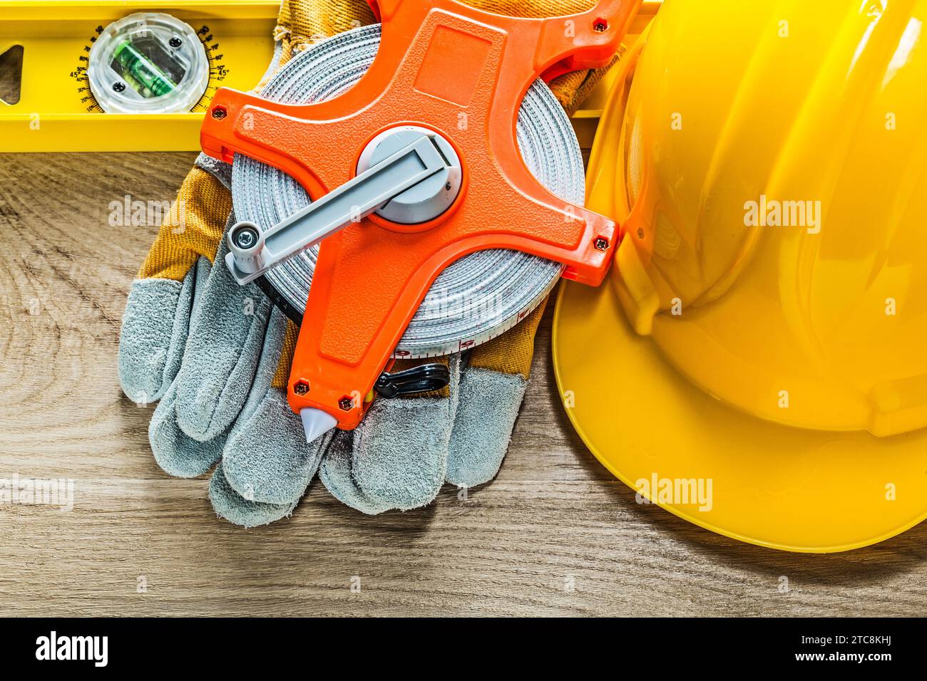 Gants de protection de niveau construction ruban de mesure casque de construction sur planche de bois Banque D'Images