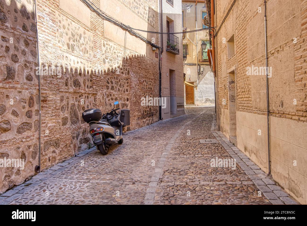 Moto garée dans une ancienne rue étroite de Tolède historique, Espagne Banque D'Images