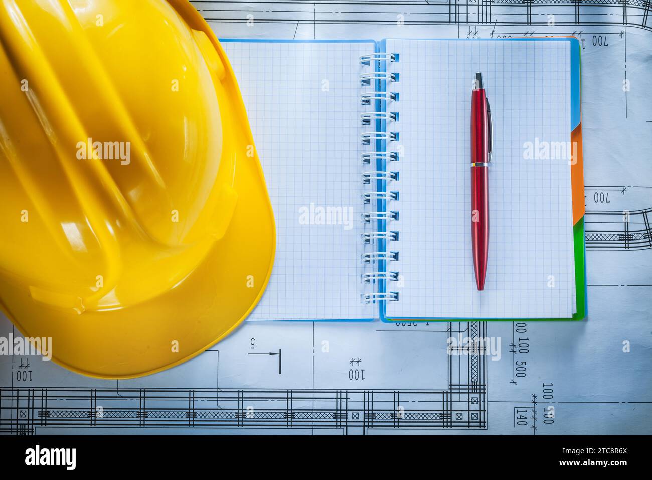 Casque de sécurité, cahier, stylo sur le plan de construction Banque D'Images