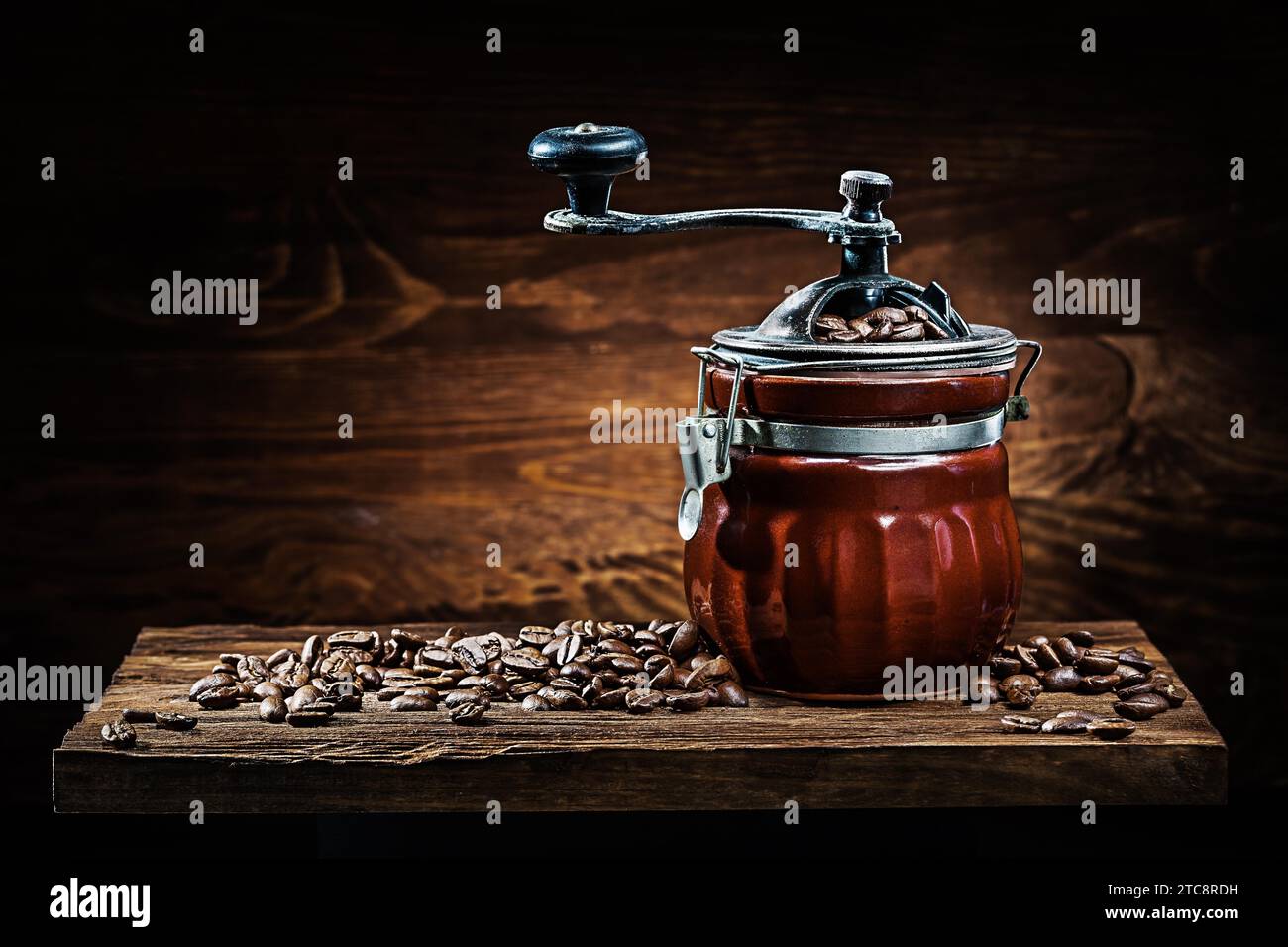 Moulin à café en céramique vintage avec des grains sur planche de bois Banque D'Images