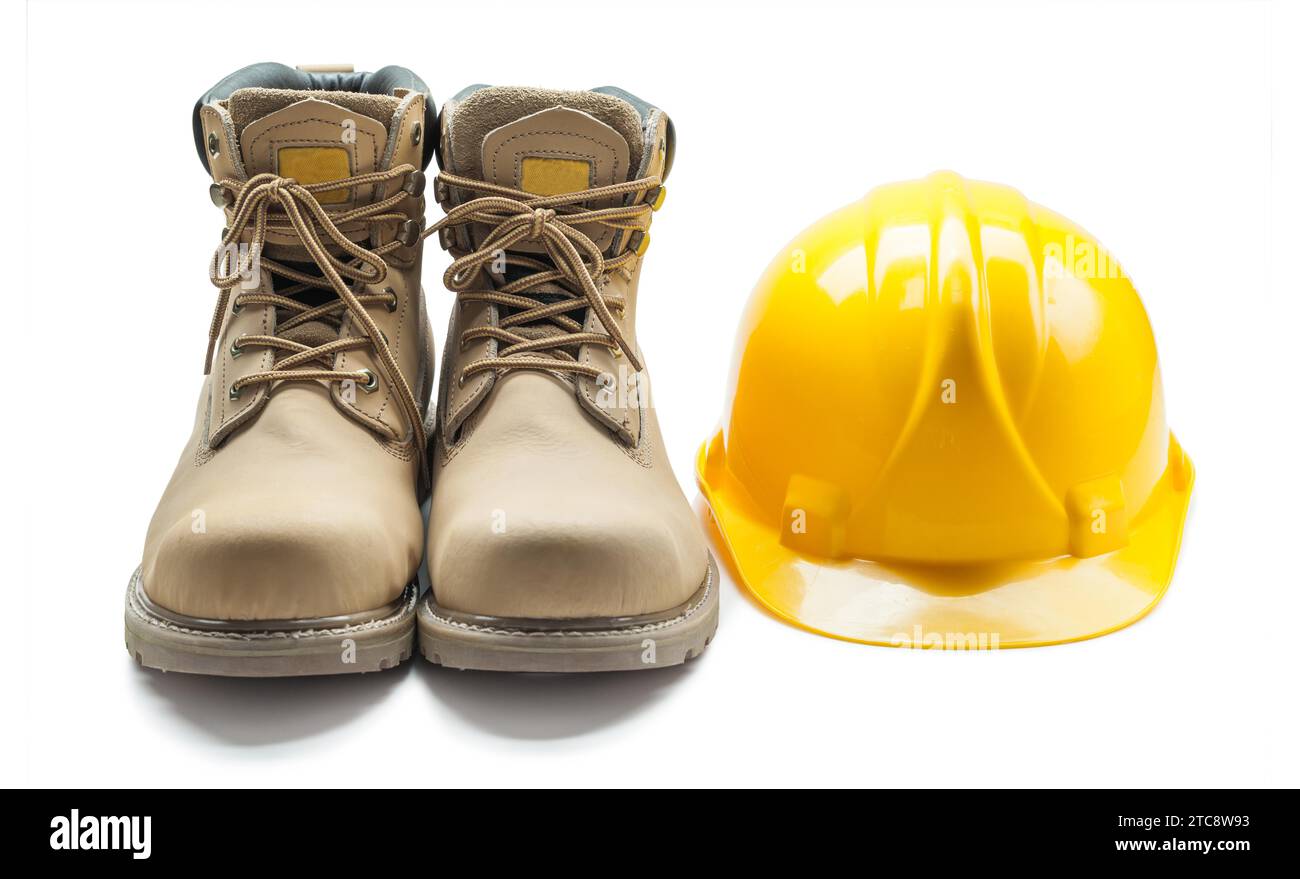 Outils de construction bottes de travail en cuir et casque jaune sur fond blanc Banque D'Images