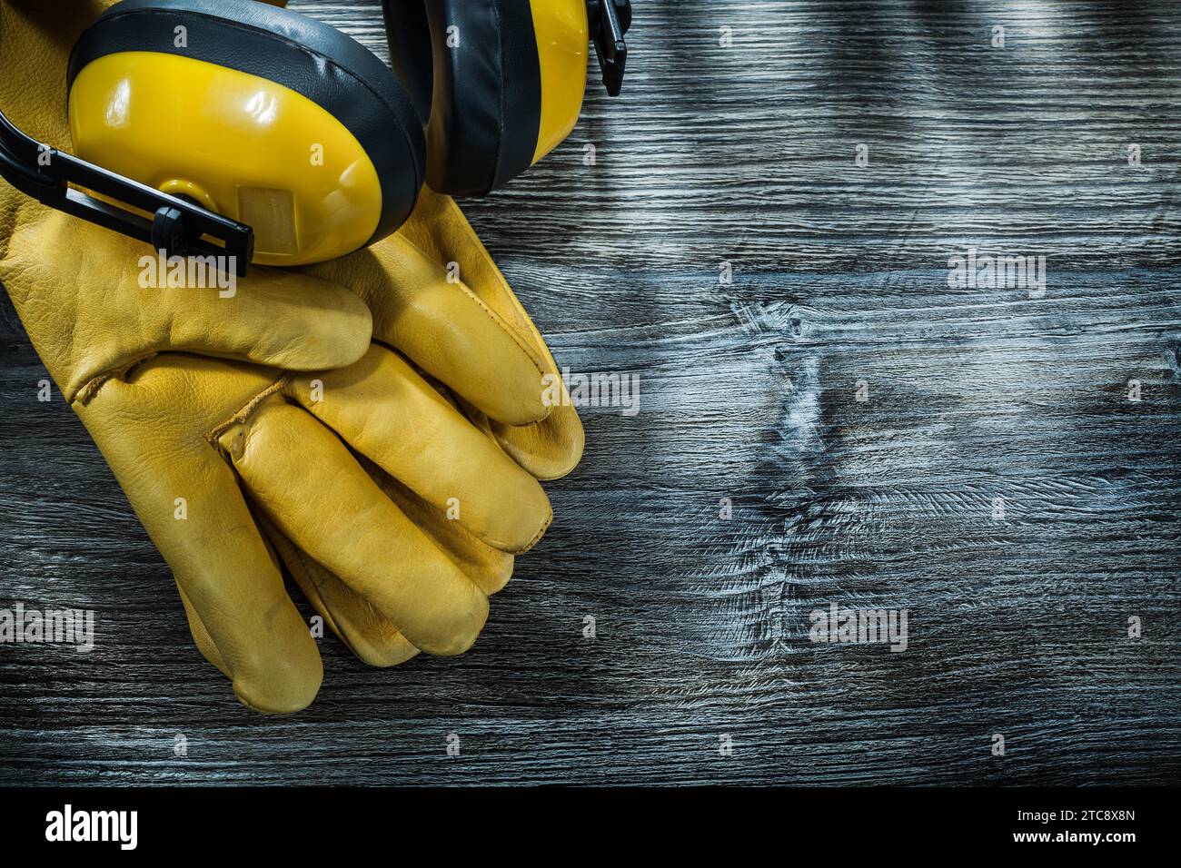 Gants de protection en cuir cache-oreilles sur planche de bois Banque D'Images