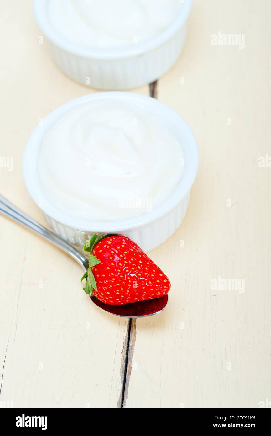 Yaourt grec biologique et fraise sur table en bois rustique blanc Banque D'Images