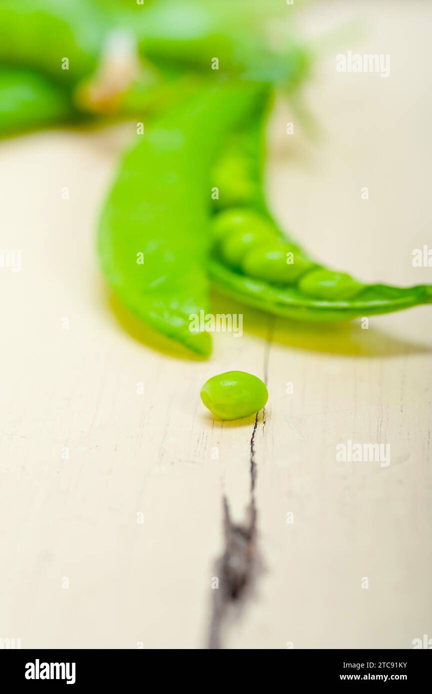 Petits pois verts frais au-dessus d'une table en bois rustique Banque D'Images