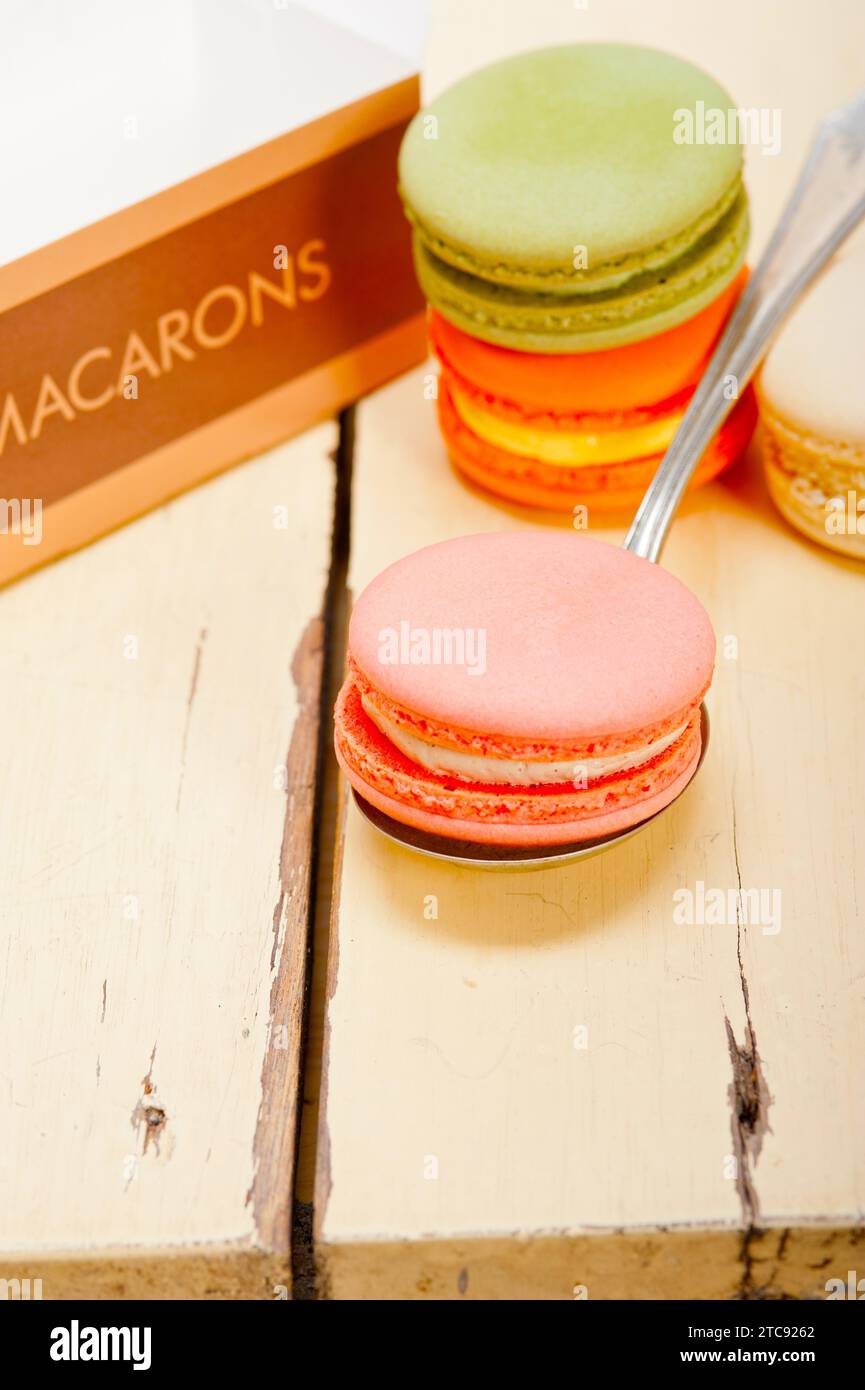 Macarons français colorés sur une table en bois rustique blanc Banque D'Images