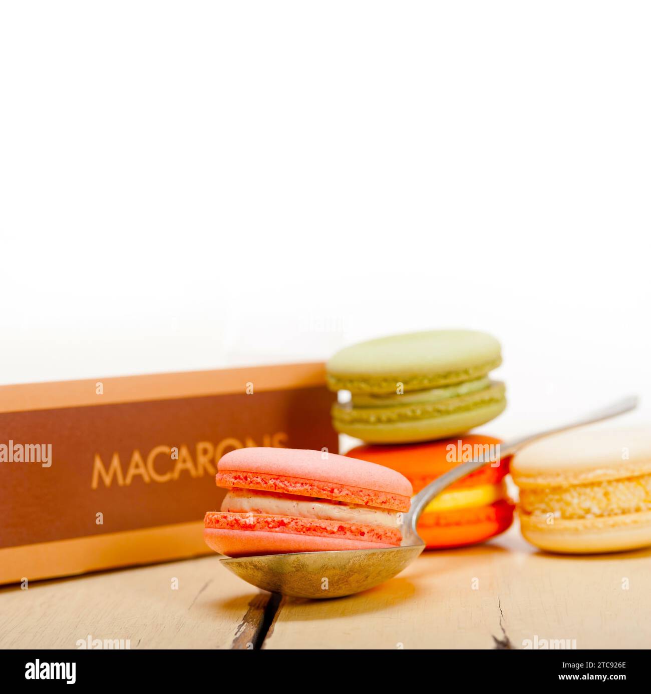 Macarons français colorés sur une table en bois rustique blanc Banque D'Images