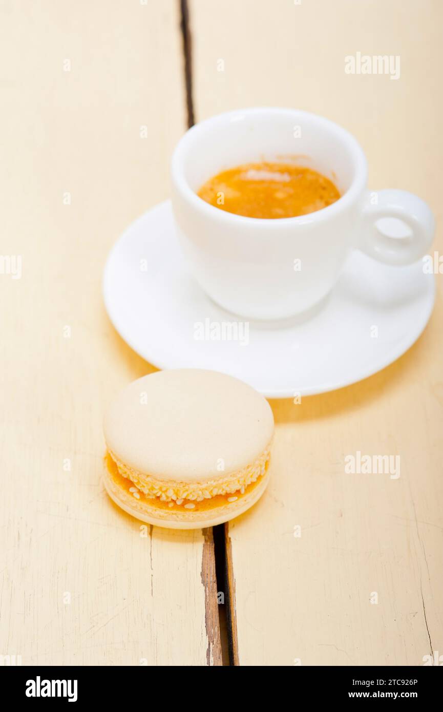 Macarons colorés avec café expresso sur table en bois blanc Banque D'Images