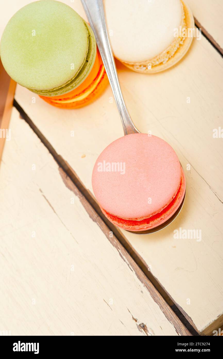 Macarons français colorés sur une table en bois rustique blanc Banque D'Images