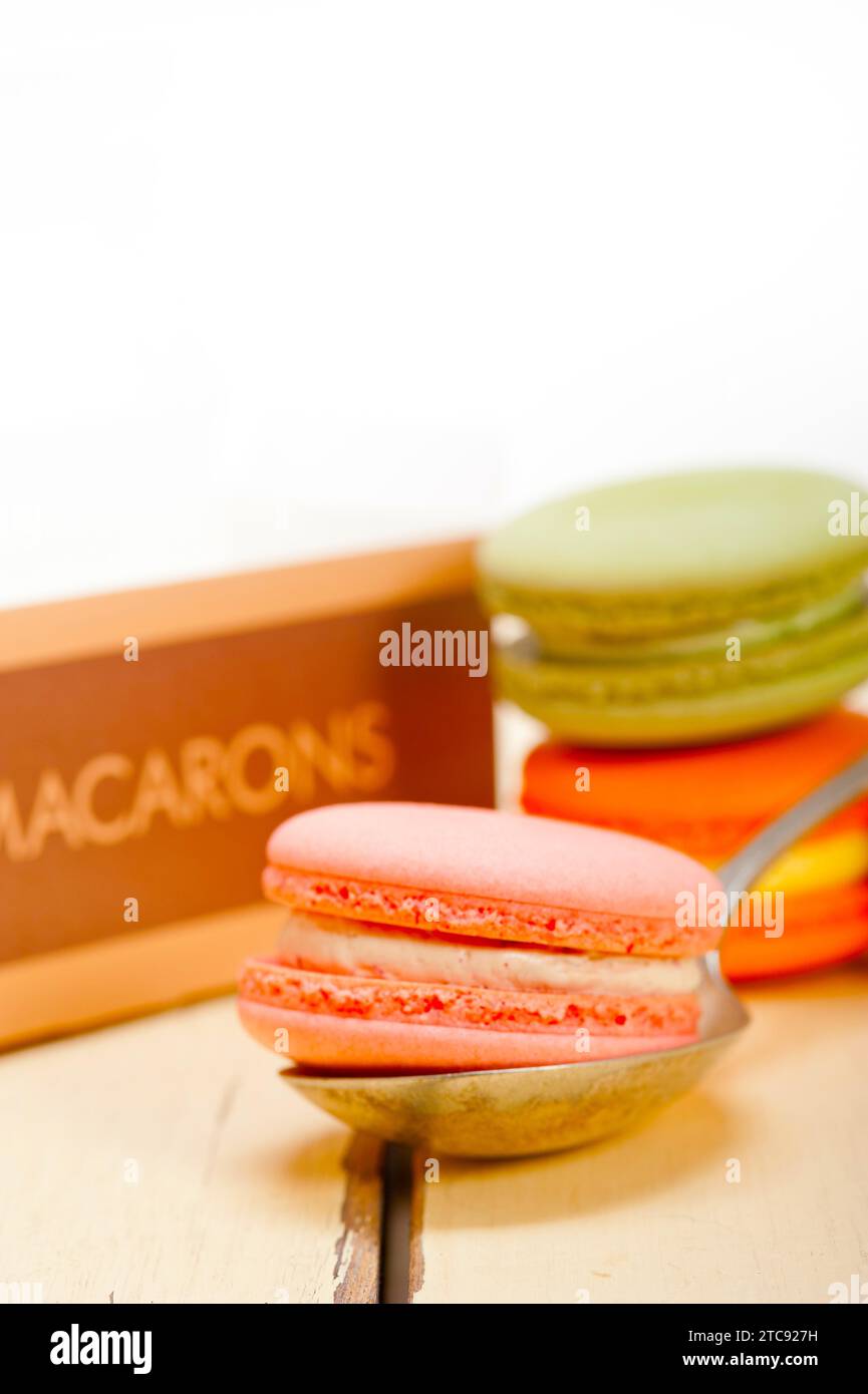 Macarons français colorés sur une table en bois rustique blanc Banque D'Images