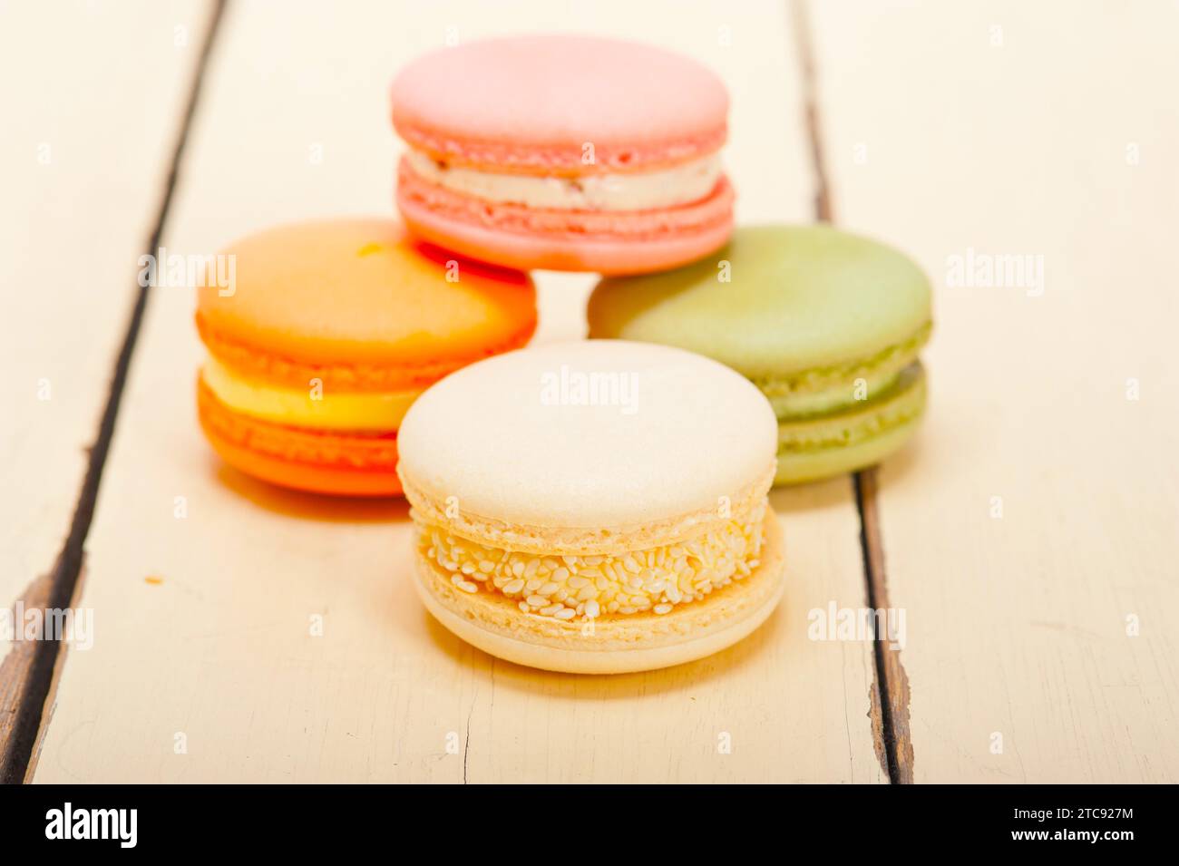 Macarons français colorés sur une table en bois rustique blanc Banque D'Images