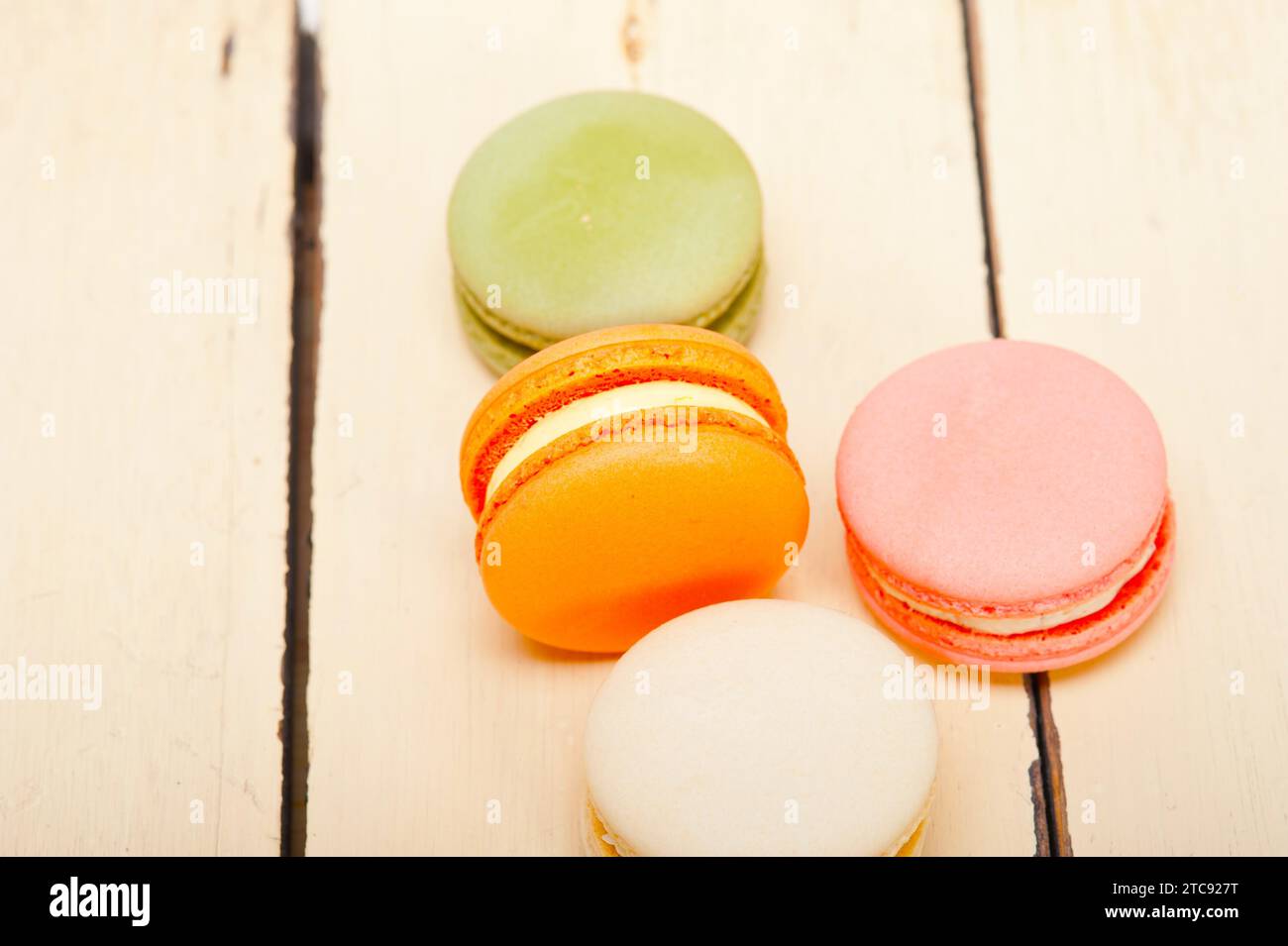 Macarons français colorés sur une table en bois rustique blanc Banque D'Images