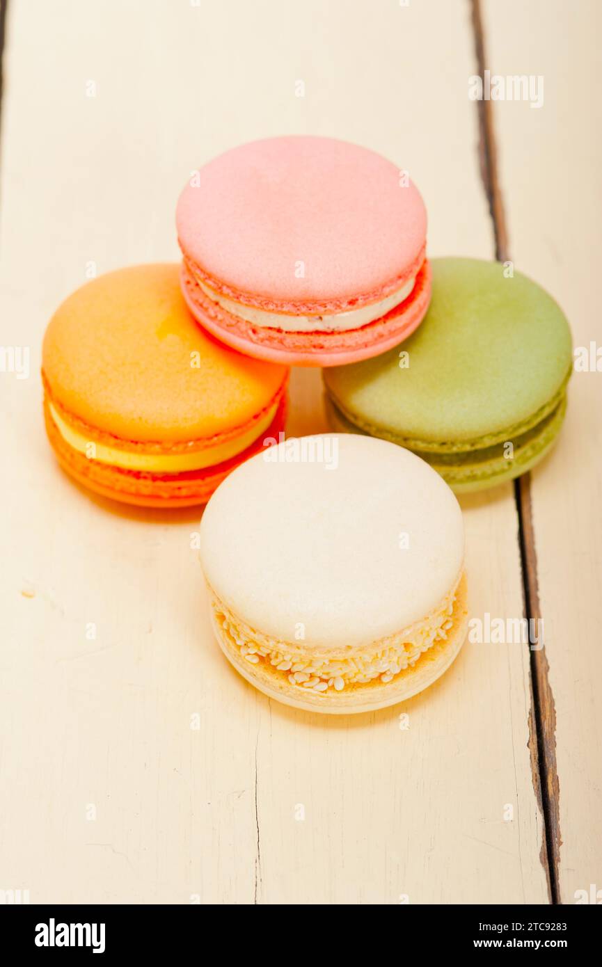 Macarons français colorés sur une table en bois rustique blanc Banque D'Images