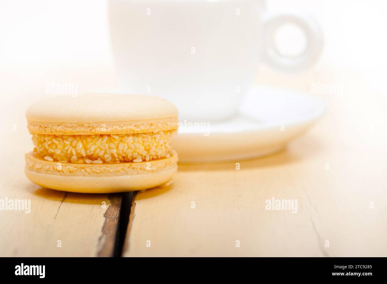 Macarons colorés avec café expresso sur table en bois blanc Banque D'Images