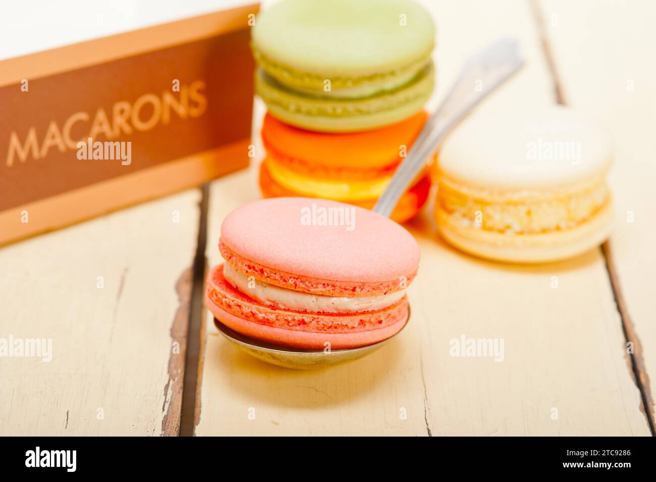Macarons français colorés sur une table en bois rustique blanc Banque D'Images
