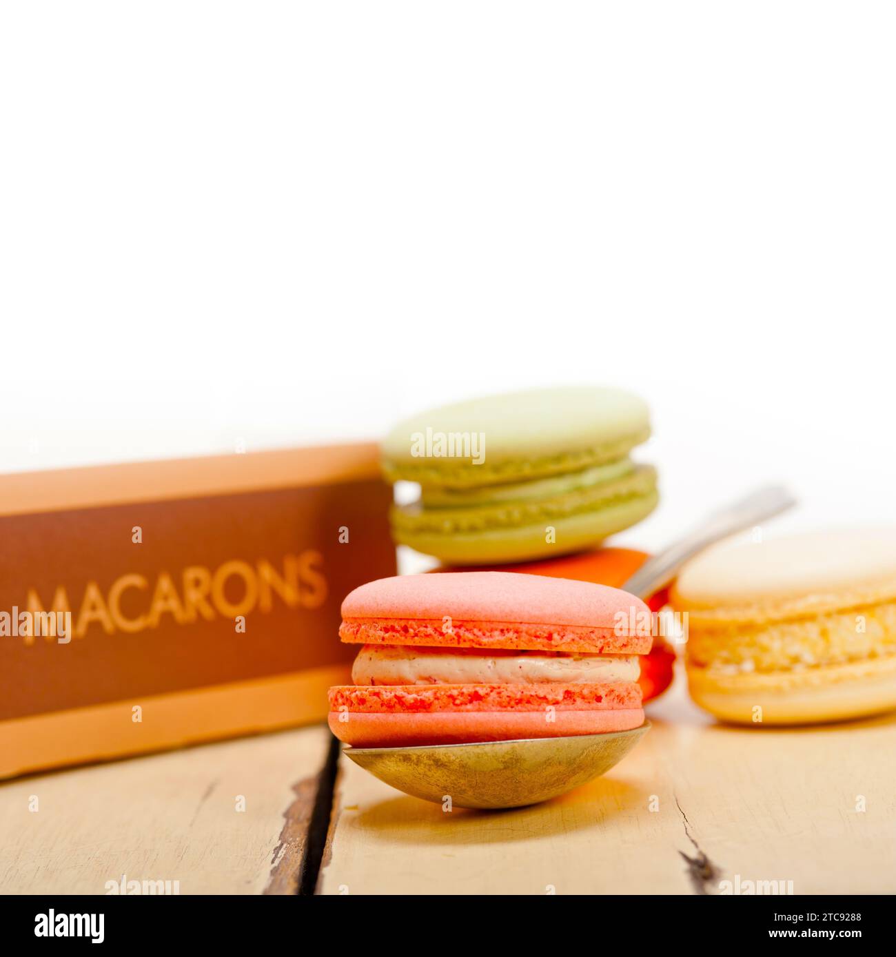 Macarons français colorés sur une table en bois rustique blanc Banque D'Images