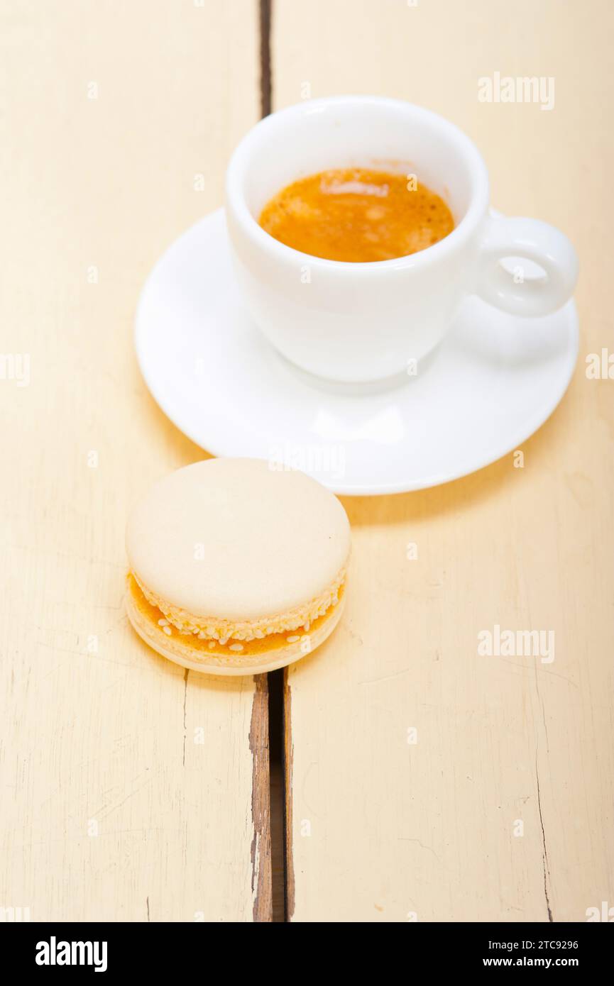Macarons colorés avec café expresso sur table en bois blanc Banque D'Images