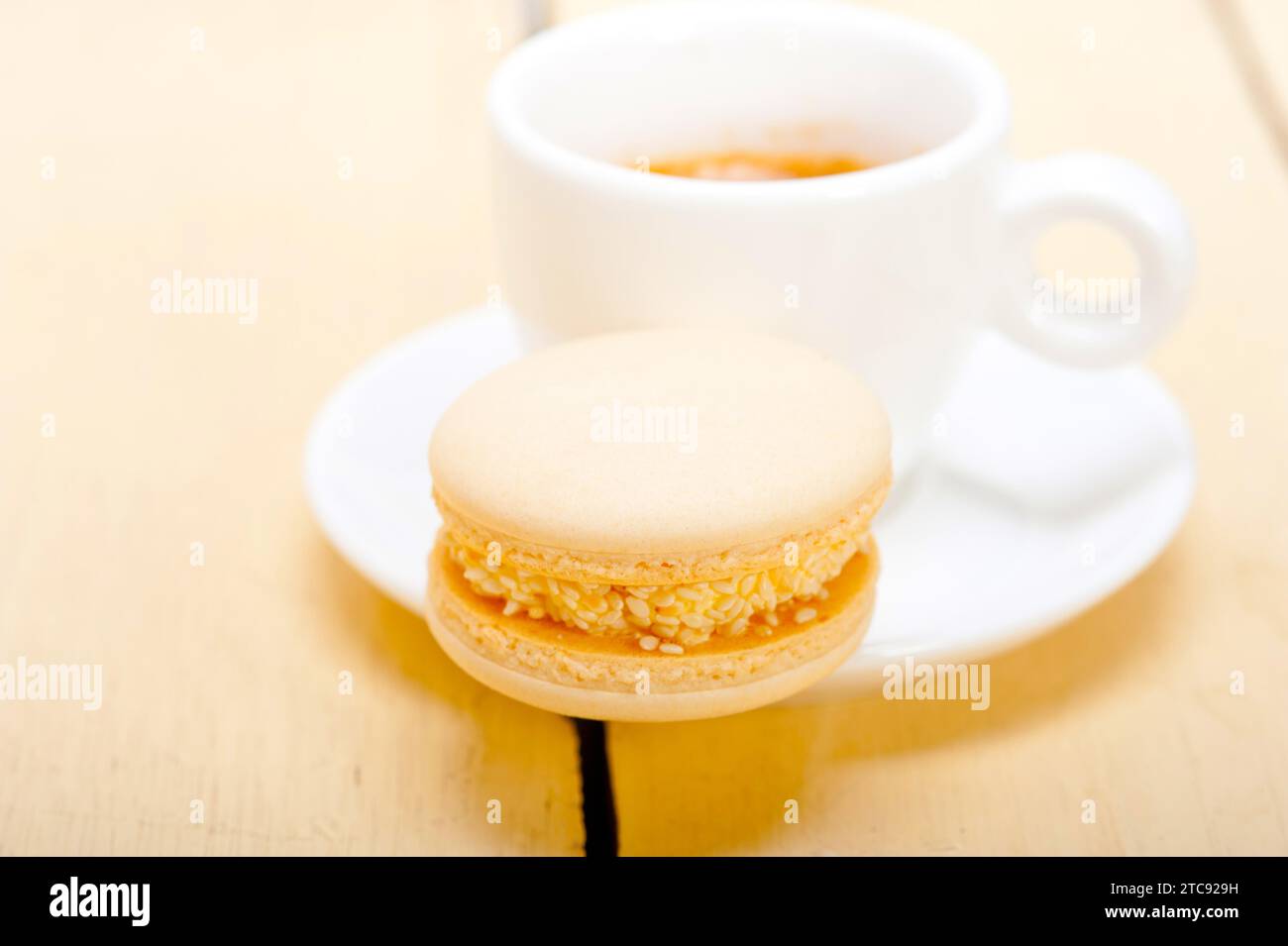 Macarons colorés avec café expresso sur table en bois blanc Banque D'Images