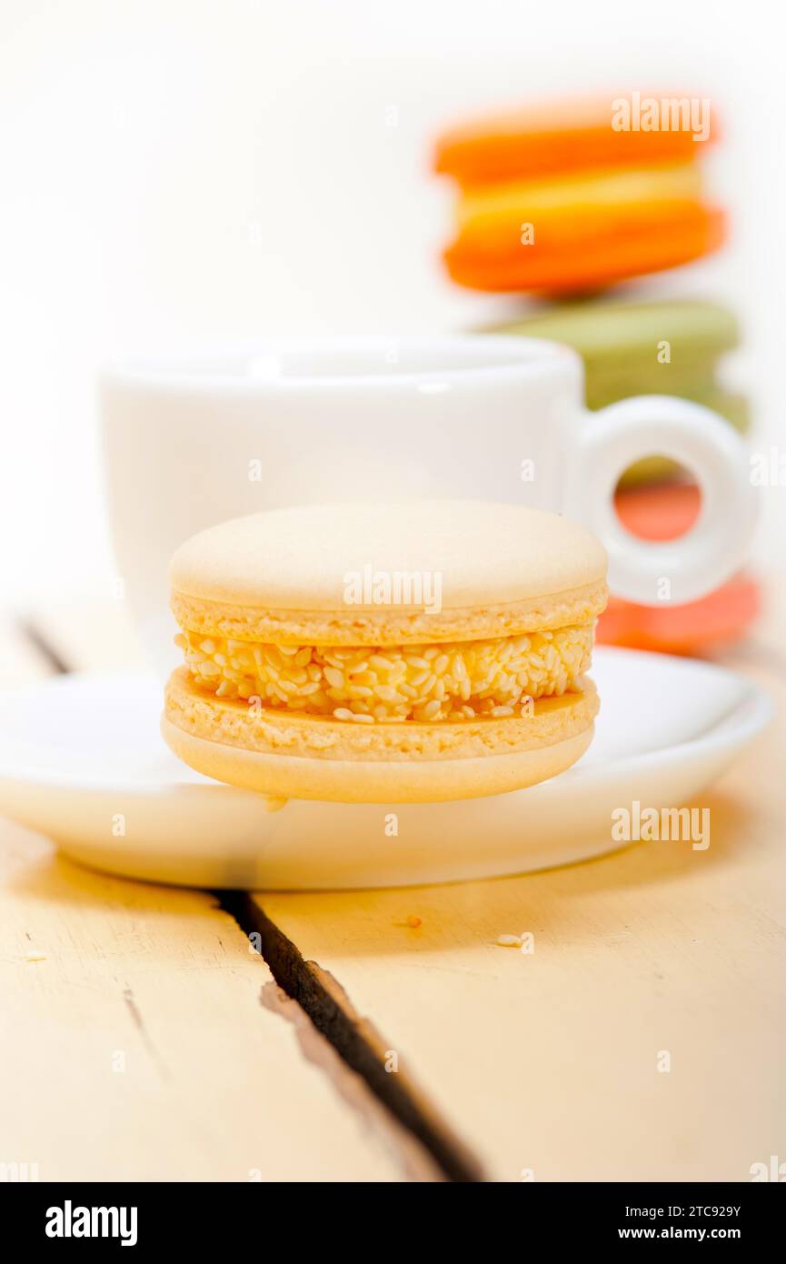 Macarons colorés avec café expresso sur table en bois blanc Banque D'Images