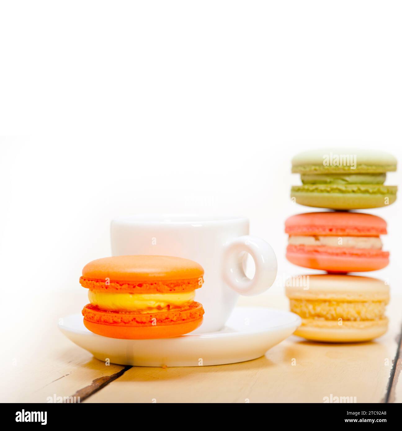 Macarons colorés avec café expresso sur table en bois blanc Banque D'Images