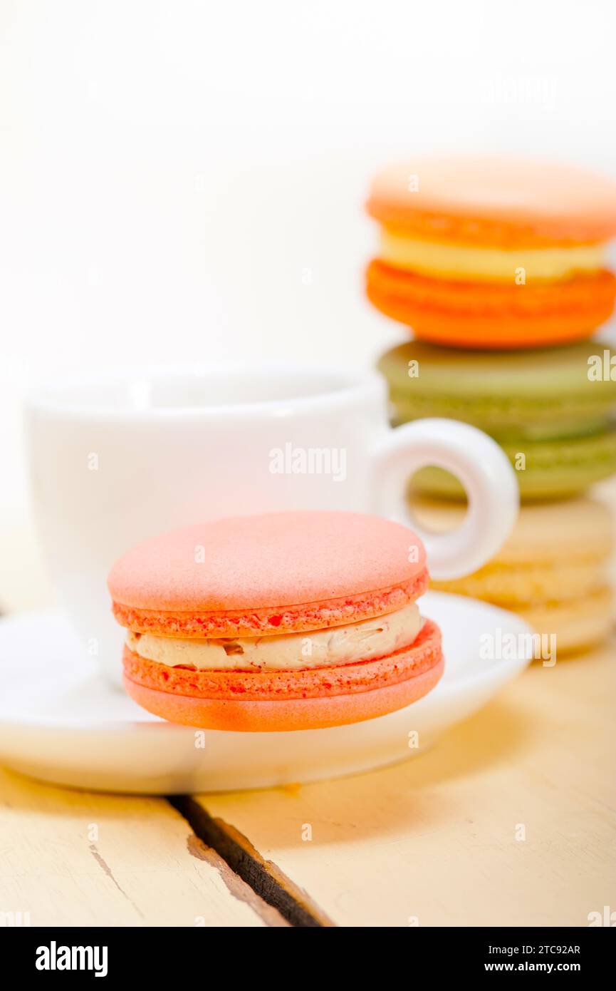 Macarons colorés avec café expresso sur table en bois blanc Banque D'Images