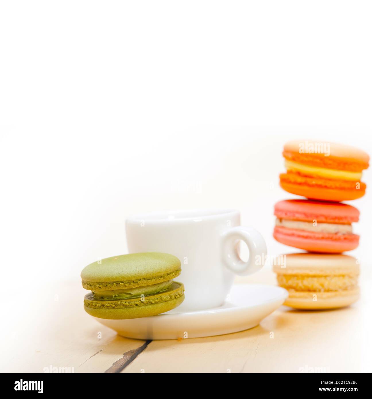Macarons colorés avec café expresso sur table en bois blanc Banque D'Images