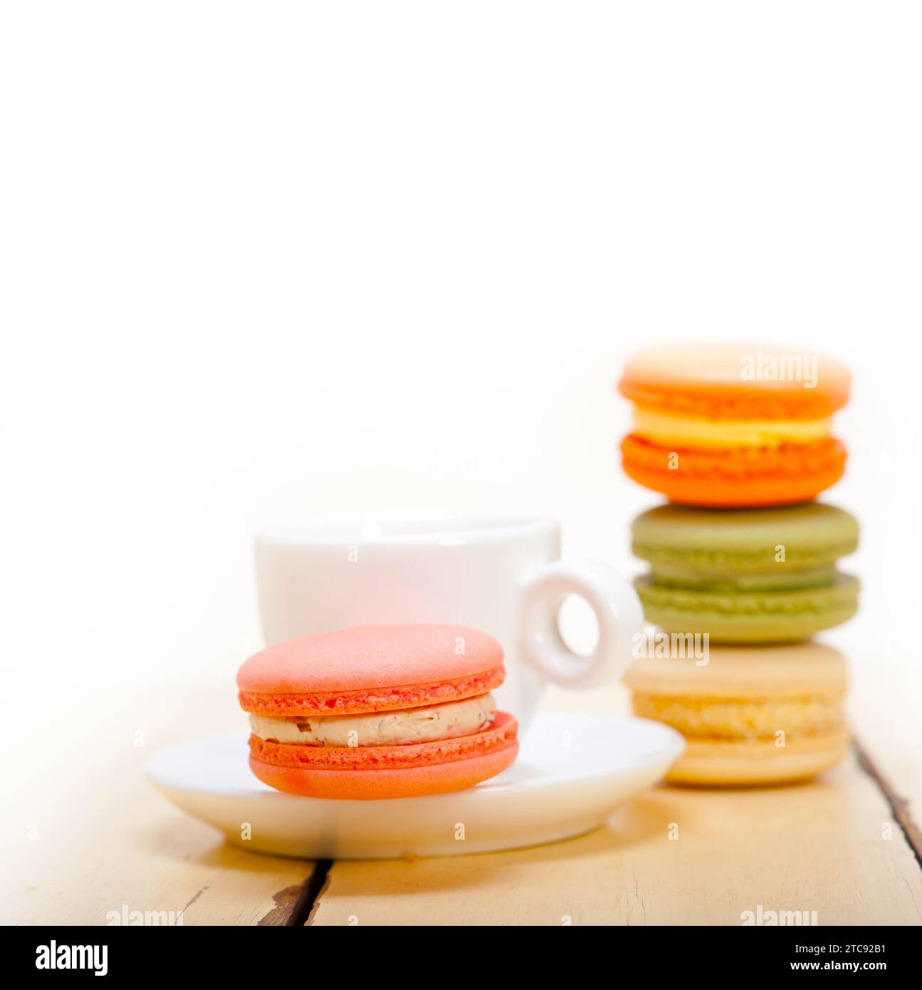 Macarons colorés avec café expresso sur table en bois blanc Banque D'Images