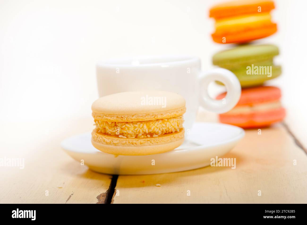 Macarons colorés avec café expresso sur table en bois blanc Banque D'Images