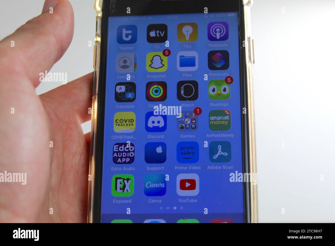 Une photo rapprochée d'une personne défilant sur les applications sur l'écran d'accueil de son iPhone. Banque D'Images