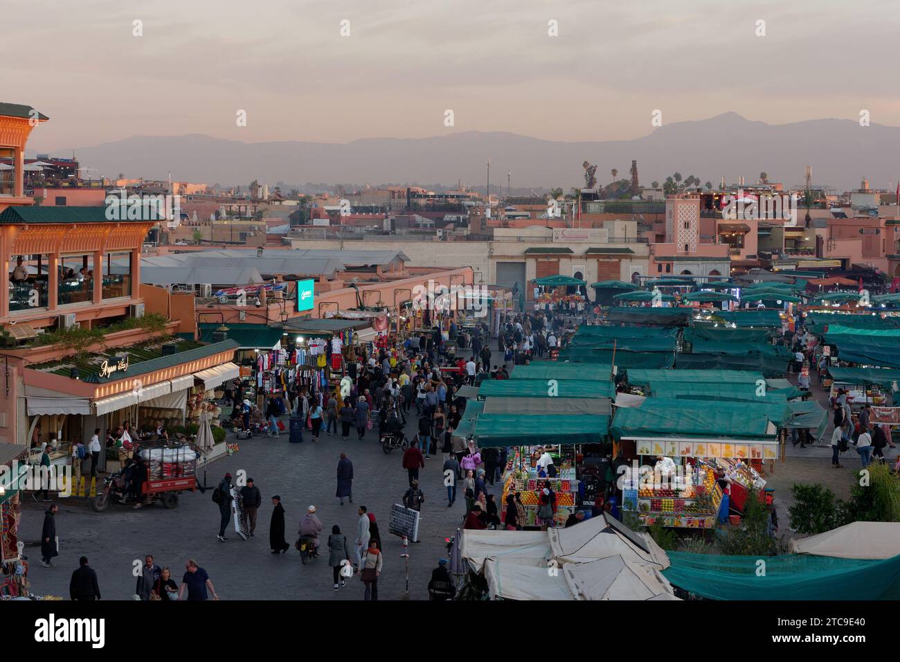 Vue sur la place Jemaa el-Fna dans la soirée au coucher du soleil avec les montagnes derrière. Marrakech alias Marrakech, Maroc, 11 décembre 2023 Banque D'Images