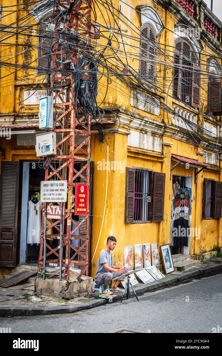Hoi an, Vietnam, 20 novembre 2022 : un artiste travaille sur un coin de rue dans le centre historique de la ville de Hoi an au Vietnam Banque D'Images