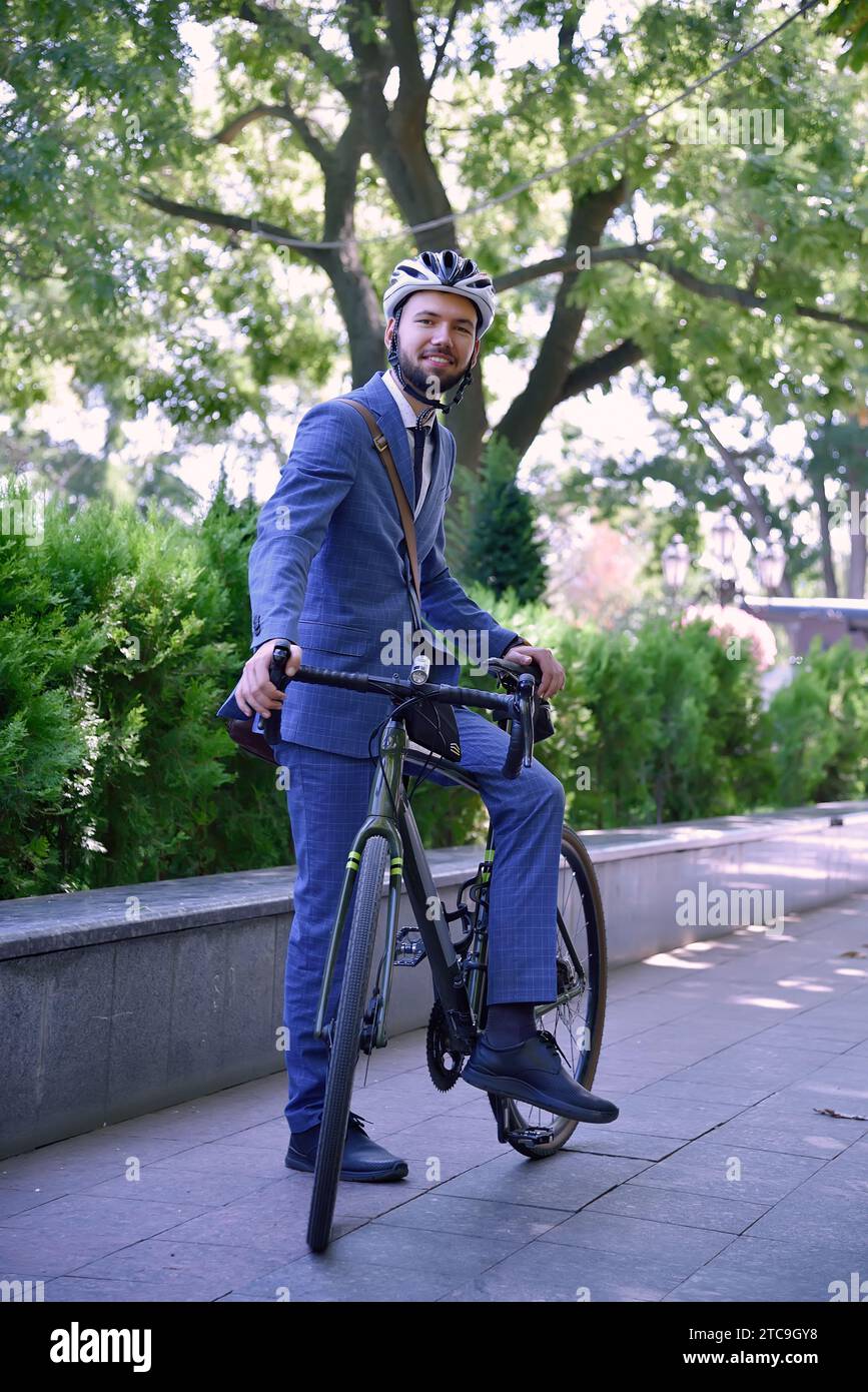 Homme d'affaires barbu en costume et casque avec vélo. Concept de style business et urbain. Gros plan Banque D'Images