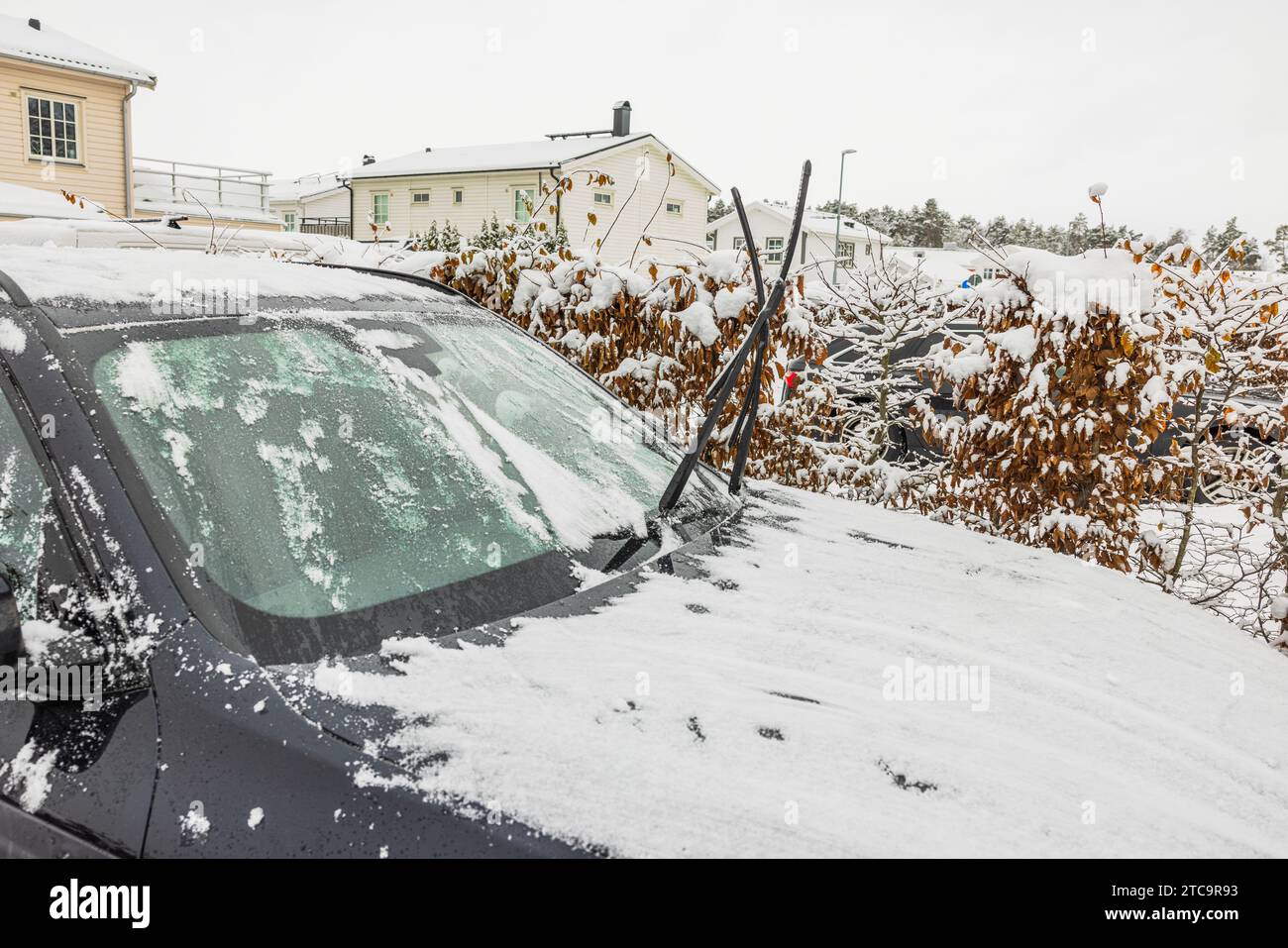 Vue rapprochée d'une voiture dans la glace et la neige, avec des essuie-glaces surélevés par une froide journée d'hiver. Suède. Banque D'Images