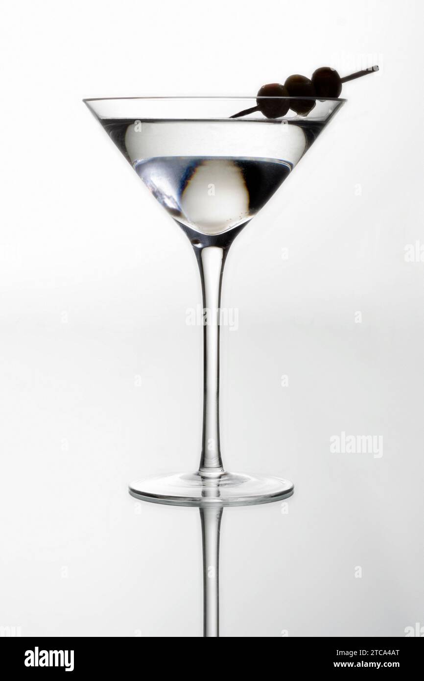 Cocktail Martini avec silhouette d'olives sur un fond gris clair Banque D'Images