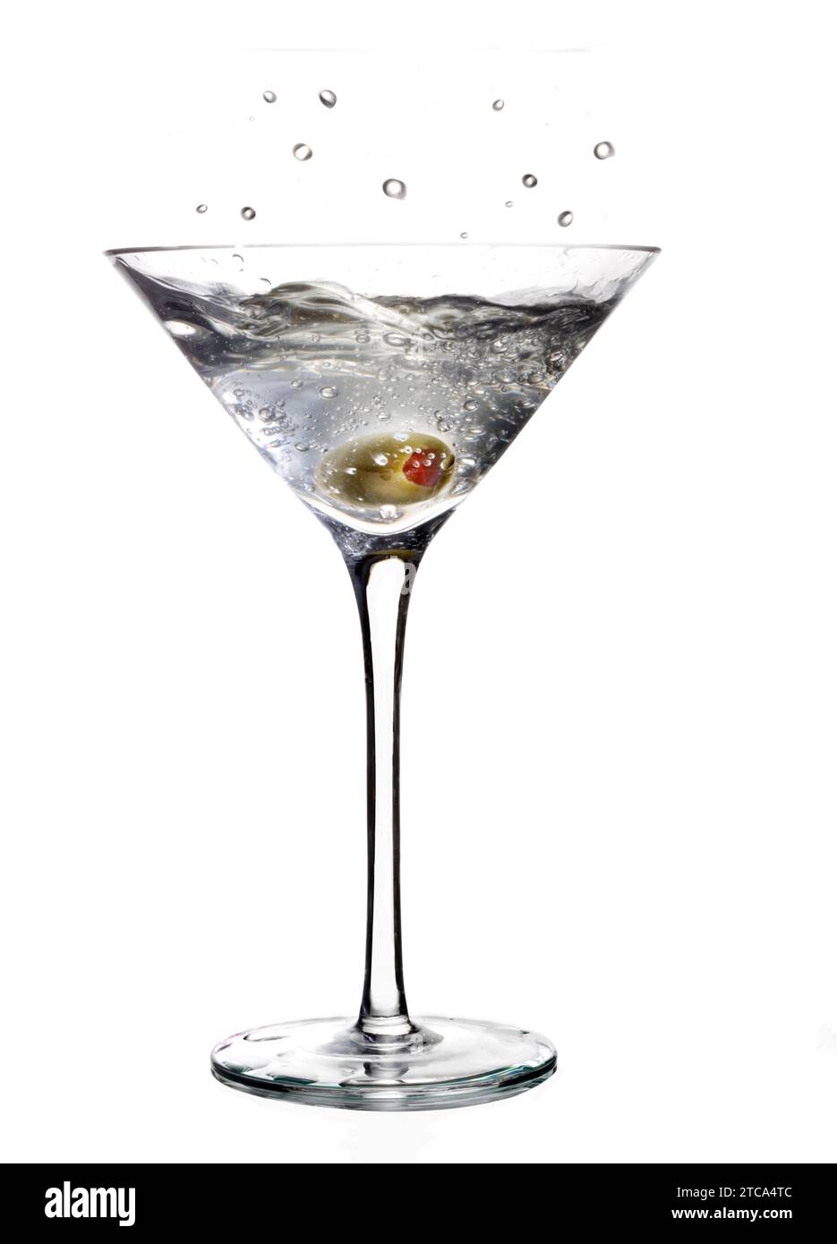 Éclaboussure de boisson mélangée Martini avec garniture d'olive sur un fond gris clair avec reflet Banque D'Images