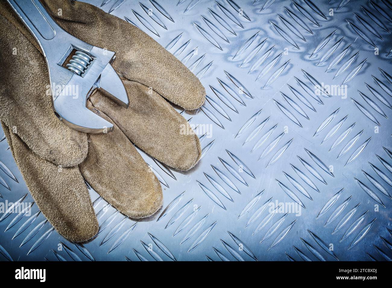 Gants de sécurité en cuir clé réglable sur plaque damier concept de construction Banque D'Images