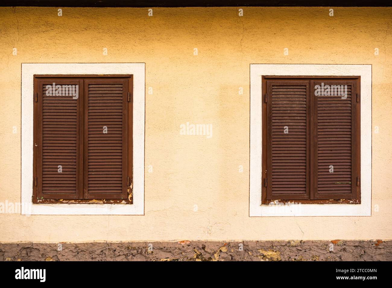 Deux fenêtres avec volets en bois brun sur maison autrichienne. La tradition historique concept Banque D'Images