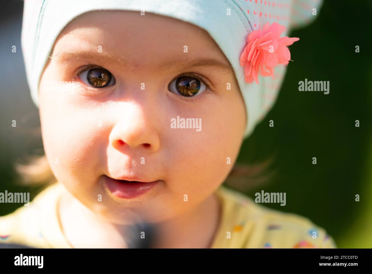 Little Baby Girl Portrait en extérieur. Enfant mignon sur la nature de l'arrière-plan. Copie de l'espace sur la droite Banque D'Images