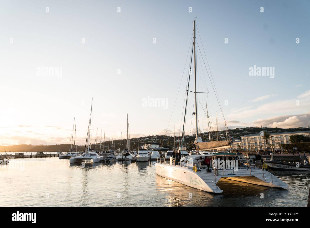 Port de Knysna au coucher du soleil avec un catamaran partant sur une croisière au coucher du soleil comme une activité de loisirs concept de tourisme et de voyage Banque D'Images