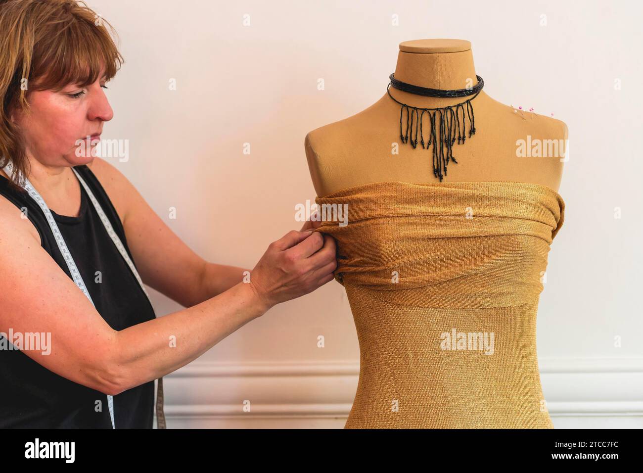 Créateur de mode mettant des épingles dans le tissu sur le mannequin Banque D'Images