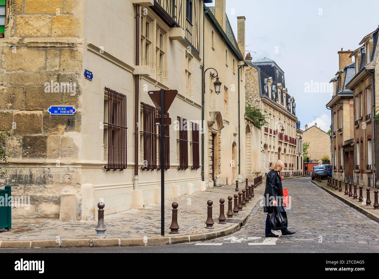 C'est une femme inconnue traversant la route dans le centre historique le 15 mai 2015 à Reims, France. Banque D'Images