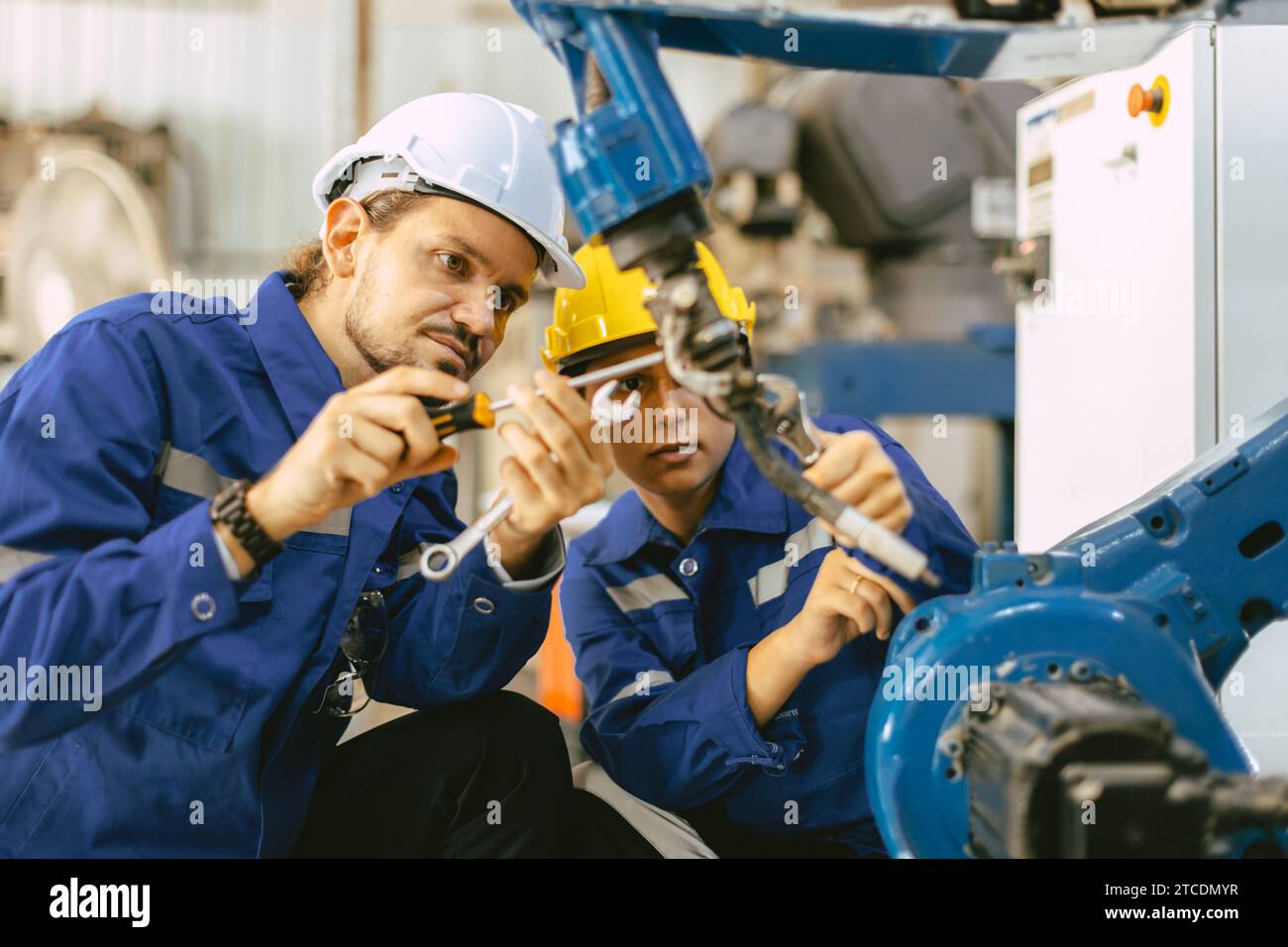 Le service de réparation de l'équipe d'ingénieurs remplace la partie cassée du bras de soudure robotique automatique de l'industrie. machine de soudage robot de maintenance de réparation de personnel. Banque D'Images