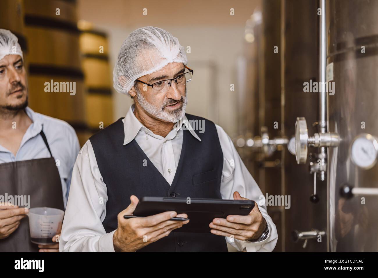 Viticulteur professionnel travaillant dans une grande usine de vinification moderne alcool alcool alcool industrie du contrôle de la qualité et de la fermentation surveillent la couleur vintage à Banque D'Images