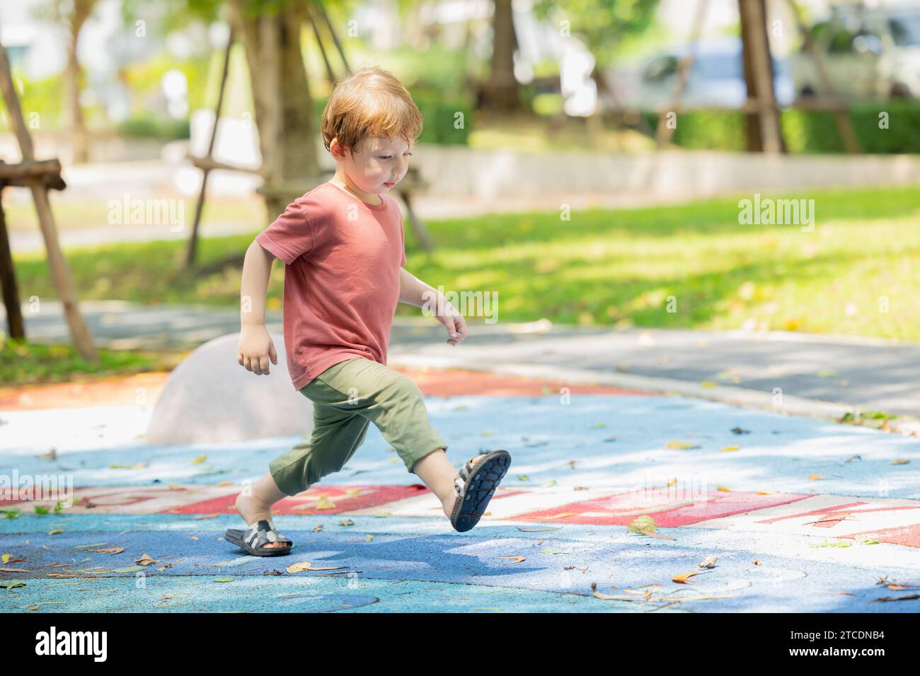 joyeux garçon amusant rire enfant souriant profiter de l'activité de jeu à l'aire de jeux parc extérieur été. Banque D'Images