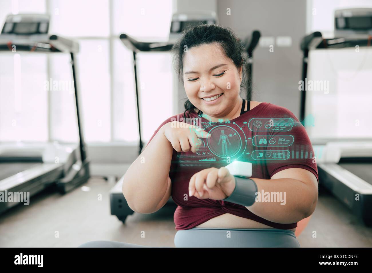 les femmes graisseuses saines et heureuses utilisent des trackers de fitness de dispositif de technologie scientifique portable intelligents affichent des informations d'aperçu d'activité de corps d'hologramme. Banque D'Images