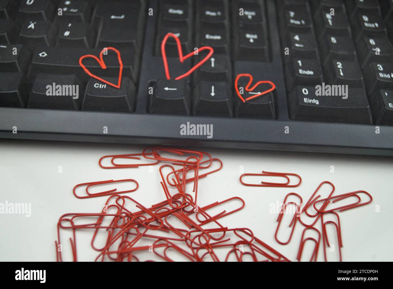 clavier avec trombones rouges, trois d'entre eux en forme de coeur, amour dans le bureau Banque D'Images