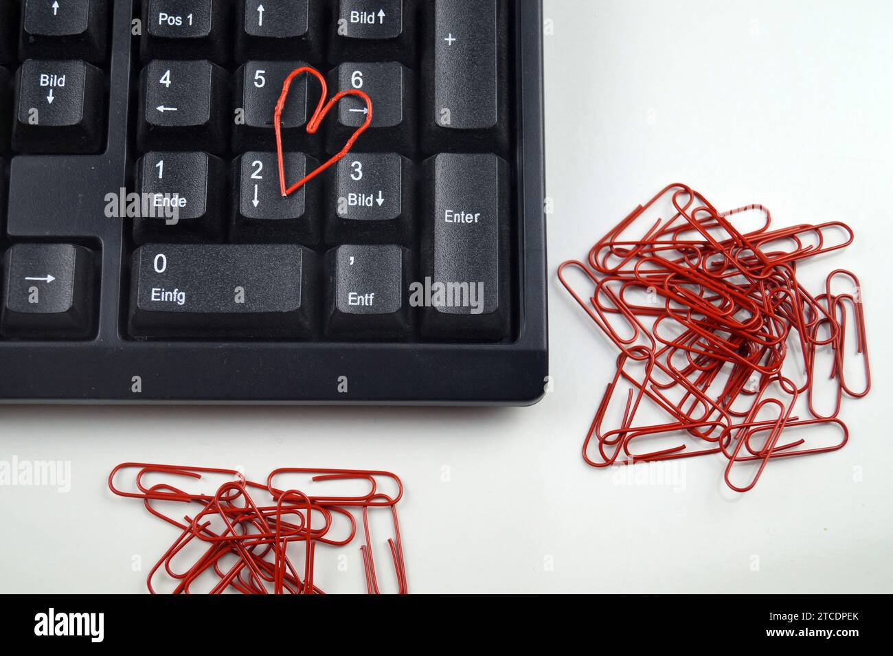 clavier avec trombones rouges, l'un d'eux en forme de coeur, amour au bureau Banque D'Images